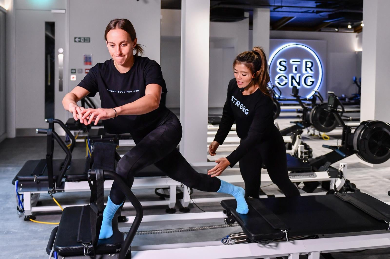 Chou Lim (STRONG Studio Owner) teaching a student on a Pilates reformer in her 'STRONG' Islington Studio.