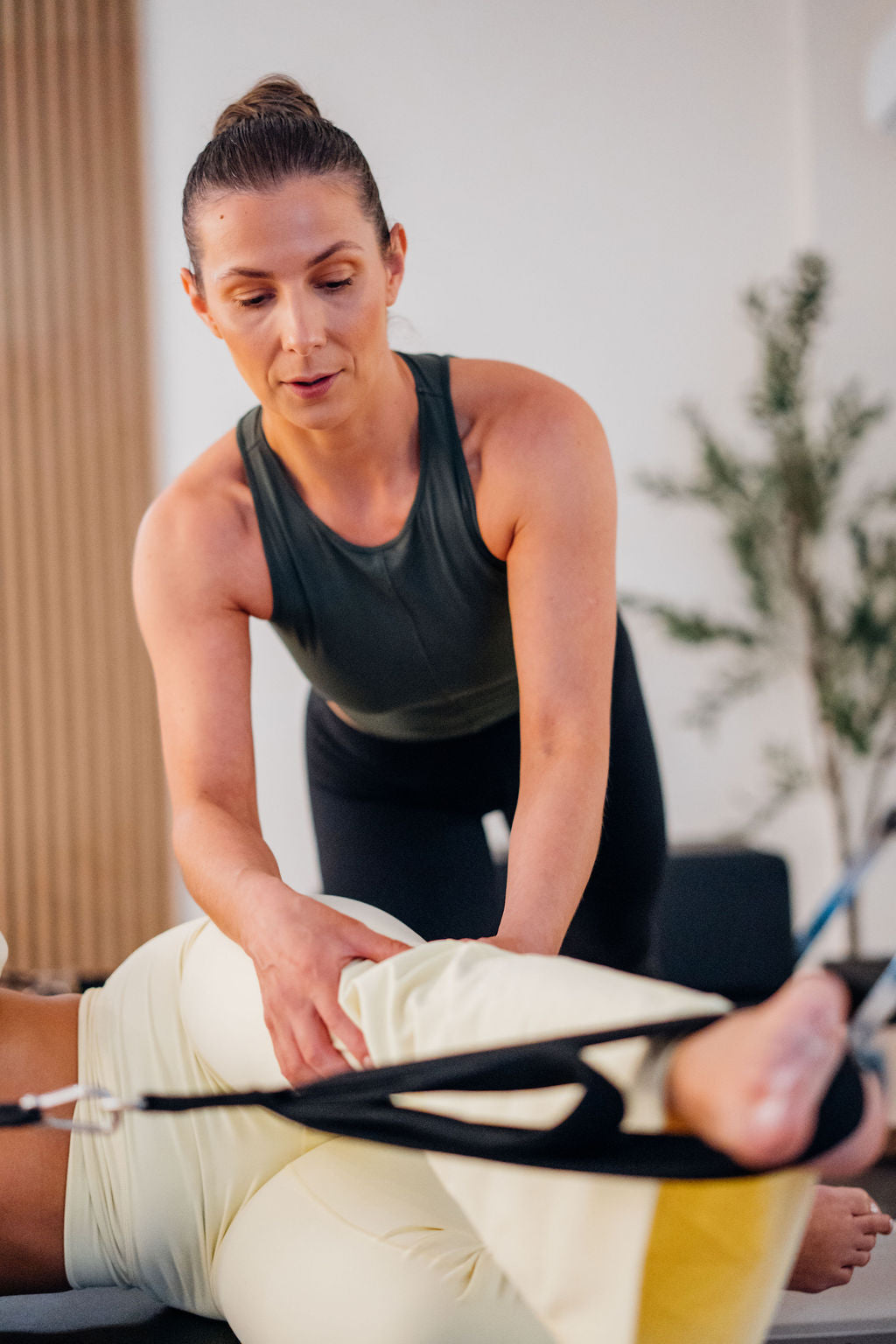 Pilates student posing with a pilates ball on a reformer bed